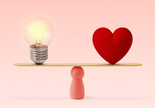Light,Bulb,And,Heart,On,Scale,On,Pink,Background-,Concept